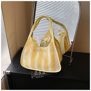 Detail view of yellow striped mesh dumpling bag featuring a round handle and floral accents