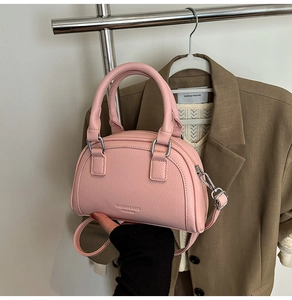 Détails du sac bowling rose montrant le cuir grainé et les finitions métalliques
