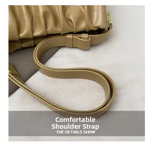 Detail of adjustable khaki shoulder strap and gold buckle on ruched cloud handbag