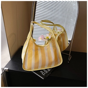 Detail of yellow striped mesh tote bag with synthetic leather handles and flower decor