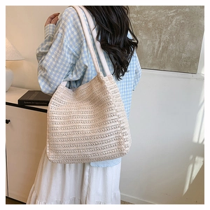 Close-up of beige woven tote bag with hollow knit patterns shown in a lifestyle home setting
