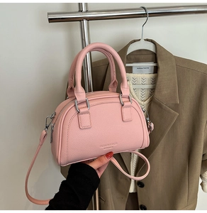 Détail du sac bowling en cuir rose grainé avec fermeture éclair argentée et logo