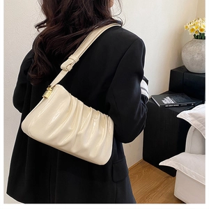 Detail of creamy white pleated leather shoulder bag with adjustable gold buckle hardware