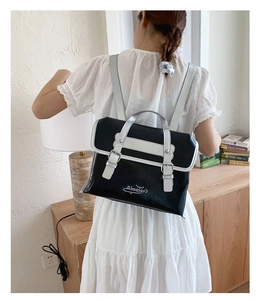 Detail showing high-capacity black and silver contrast backpack worn by a model in lifestyle setting