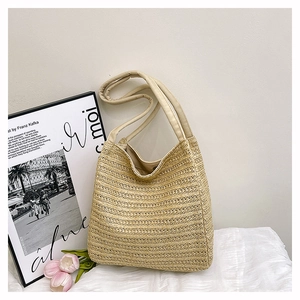 Detailed view of beige woven straw tote bag with fine texture and soft fabric handles