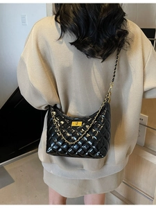 Chic black quilted underarm bag with gold chain strap and glossy leather finish
