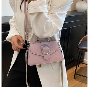 Detail der lila Handtasche mit Lychee-Struktur und silberner Schnalle am Model
