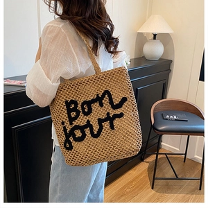 Détail du sac cabas en paille tissée avec broderie Bonjour dans un cadre de vie intérieur