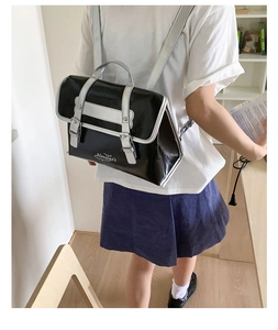 Detail of a chic black and white color-block backpack with flap and metal buckle