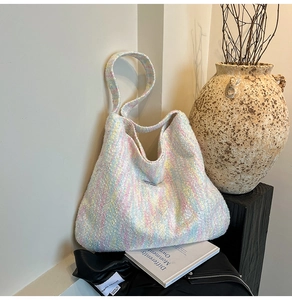 Nahaufnahme der Strickstruktur und des Logos auf einer bunten Makronen-Tasche