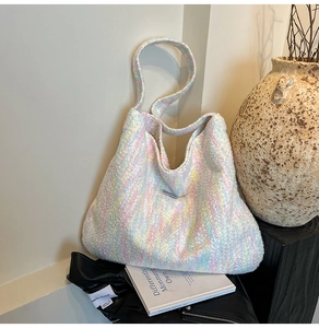 Detailansicht der gewebten Tweed-Textur einer großen Hobo-Schultertasche in Makronenfarben