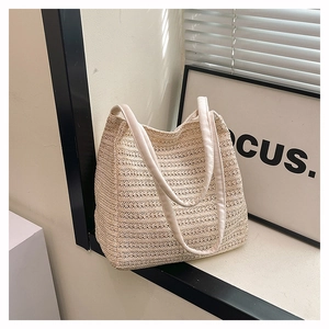 Detailed view of natural beige woven tote bag texture and wide reinforced shoulder straps