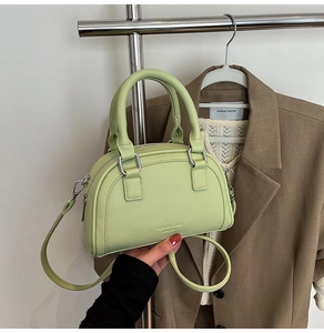 Détails du cuir grainé vert clair et des finitions métalliques argentées du sac bowling