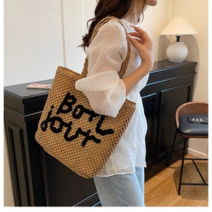 Détails du sac cabas en paille tressée avec broderie noire Bon Jour sur le devant