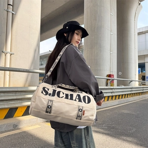 Off-white large capacity cylinder travel bag with SJCHAO lettering in street setting