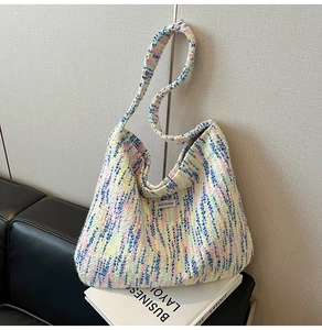Nahaufnahme einer bunten Strick-Tragetasche mit Jollyhouse-Label auf dem Sofa