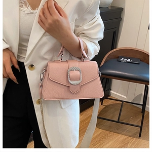 Detail der rosa Handtasche aus Kieselleder mit Silberschnalle und breitem Stoffgurt