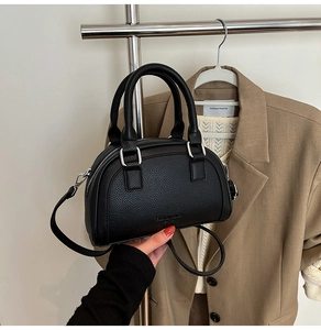 Détail d'un sac bowling en cuir noir texturé litchi avec finitions métalliques argentées