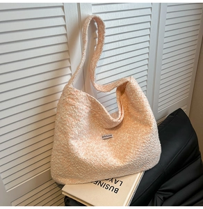 Detailtextur aus pfirsichfarbenem Bouclé-Stoff für große Tragetasche mit Jollyhouse-Label