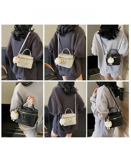 Détail de sacs à main carrés minimalistes noir et beige avec charmant pendentif agneau