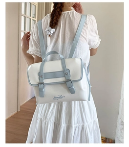 Detail of light blue and white PU leather backpack with adjustable straps and silver buckle