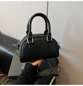 Détail de la texture cuir grainé noir et fermeture éclair métallique du sac à main