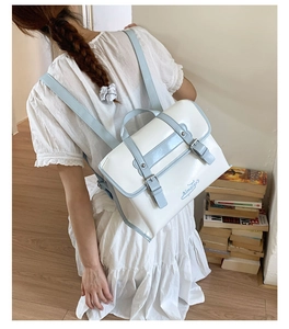 Detail of sweet preppy style white backpack with light blue straps and embroidery
