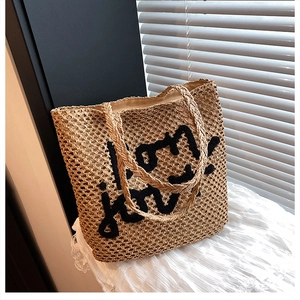 Détail du sac cabas en paille tissée avec broderie noire 'bon jour!' et doublure
