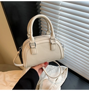 Détail du sac à main en cuir grainé blanc cassé avec boucles argentées et poignées robustes