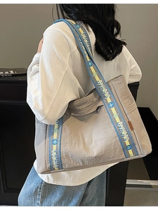 Minimalist grey large capacity tote bag with stylish blue and yellow woven shoulder straps