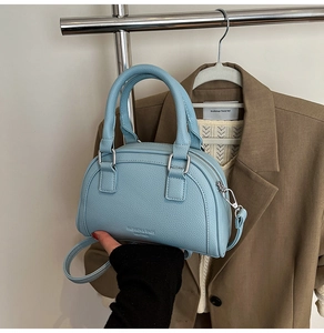 Détail du sac bowling en cuir bleu clair avec zip argenté et bandoulière réglable