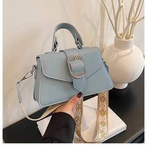 Details der hellblauen Lederhandtasche mit besticktem Vintage-Schultergurt im Fokus
