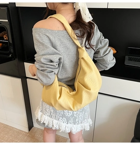 Detail of yellow lychee-grain hobo bag showing large capacity and soft texture on shoulder