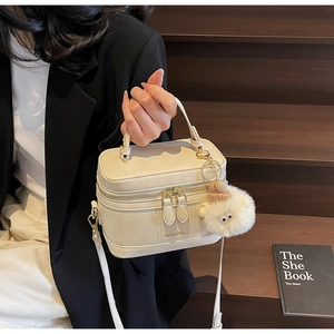 Détail du sac seau blanc crème avec logo ZAR&KCMK et charmant pendentif agneau en peluche