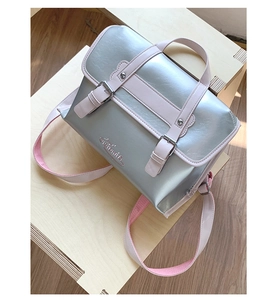 Close-up of metallic silver leather bag with pink straps and double buckle design