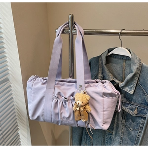 Detailed shot of lavender nylon tote bag with pleated front pocket and cute bear charm