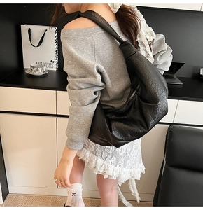 Fashionable black pleated hobo shoulder bag shown on model for daily casual wear style