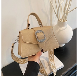 Detailansicht der beigen Handtasche mit Litschistruktur und Ethno-Besticktem Gurt