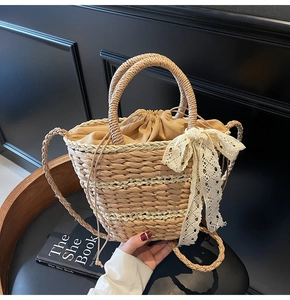 Detail of straw woven bucket bag with lace bow and drawstring liner on leather chair