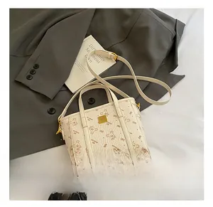 Detailed macro view of the cream leather texture with a cute bear pattern and gold logo plate