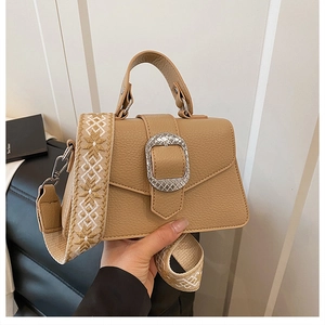 Details der khakifarbenen Lederhandtasche mit großer Silberschnalle und gemustertem Gurt