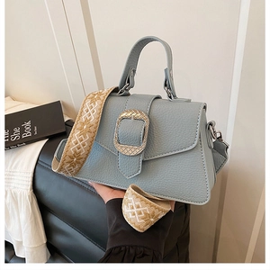 Detail der blauen Handtasche aus Narbenleder mit Vintage-Schnalle und Boho-Gurt