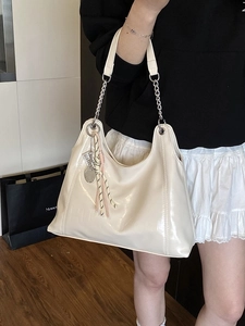 Chic beige patent leather hobo bag with chain strap and trendy tennis racket charm