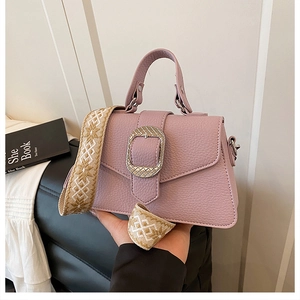 Detailansicht der fliederfarbenen Lederhandtasche mit Hufeisenschnalle und Webriemen