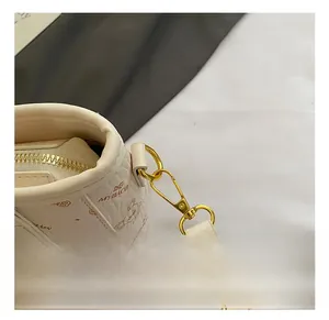 Detailed close-up of premium gold-toned metal hook and cartoon printed luxury handbag