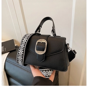 Detail der schwarzen Handtasche aus Leder mit Silberschnalle und Webriemen