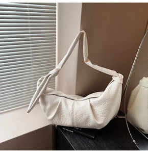 Detail of off-white crinkled leather hobo bag with unique knot shoulder strap and zipper
