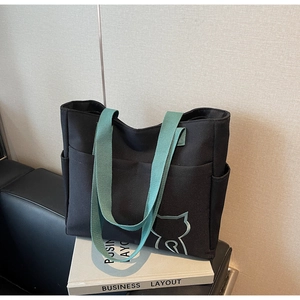 Detail view of large canvas tote bag with contrast mint green straps and side pockets