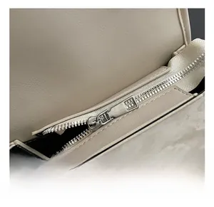 Detailed close-up of premium silver metal zipper and cream synthetic leather on stylish bag