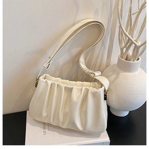 Detail of cream pleated cloud bag with adjustable strap and textured vegan leather